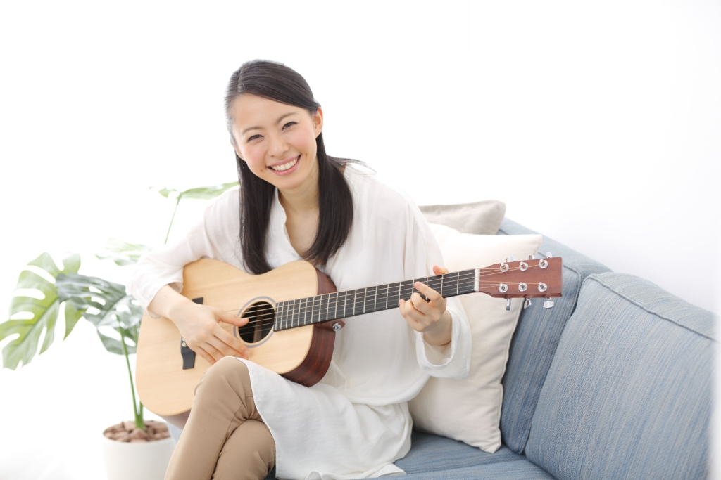 笑顔でギターを弾く女性