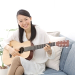 笑顔でギターを弾く女性